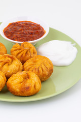 Fried Momos is a Traditional Dumpling Food From Nepal Served with Schezwan Sauce & Cream