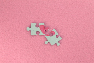 Puzzle with a red heart on the pink felt background. Two disconnected halves. Valentine's day stock...