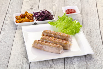 Grilled sausages served mushrooms and cabbage