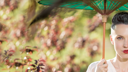 Japanese woman in kimono and with umbrella in spring or autumn park