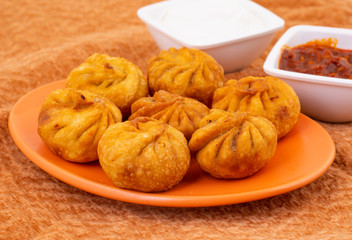 Naklejka na ściany i meble Fried Momos is a Traditional Dumpling Food From Nepal Served with Schezwan Sauce & Cream