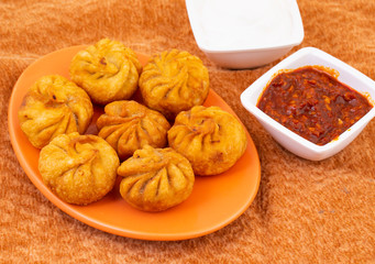 Fried Momos is a Traditional Dumpling Food From Nepal Served with Schezwan Sauce & Cream