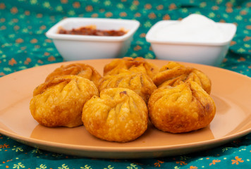 Fried Momos is a Traditional Dumpling Food From Nepal Served with Schezwan Sauce & Cream