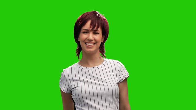 Beautiful female model posing on green screen blows kiss and shows thumb up gesture