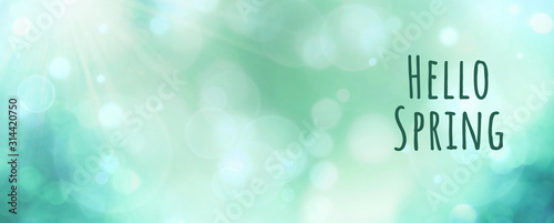 Abstract green spring background banner - hello spring text - greeting card with beautiful bokeh lights