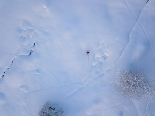 Aerial view of mountaineer hiking upwards with touring ski in snow covered backcountry. Concept of backcountry skiing.