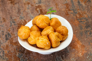 Sweet tasty profiteroles heap in the bowl