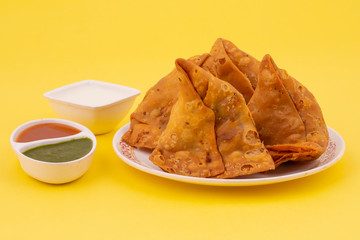 Indian Street Food Samosa or Samosas is a Crispy And Spicy Triangle Shape Snack Which Has Crisp Outer Layer of Maida & Filling of Mashed Potato, Peas And Spices. Served With Chutney, Ketchup or Curd