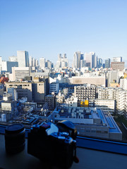 Fototapeta na wymiar blurred camera with Shinjuku skyscraper skyline building top view in the morning. Japan city urbanscape real estate.