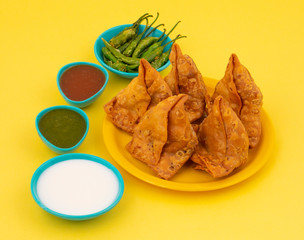 Indian Street Food Samosa or Samosas is a Crispy And Spicy Triangle Shape Snack Which Has Crisp Outer Layer of Maida & Filling of Mashed Potato, Peas And Spices. Served With Chutney, Ketchup or Curd