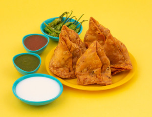 Indian Street Food Samosa or Samosas is a Crispy And Spicy Triangle Shape Snack Which Has Crisp Outer Layer of Maida & Filling of Mashed Potato, Peas And Spices. Served With Chutney, Ketchup or Curd