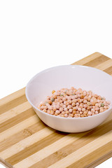 Grains of peas in a white bowl on the table.
