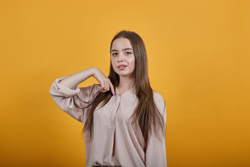 Atttractive caucasian brunette woman in fashion pastel shirt pointing fingers at herself, looking at camera isolated on orange background in studio. People sincere emotions, lifestyle concept.