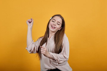 Cheerful caucasian brunette woman in fashion pastel shirt, dancing, keeping fist aside, enjoying...