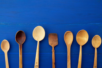 set of yellow wooden vintage spoons on a blue wooden background