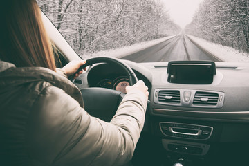 Woman driving the car on snowy road