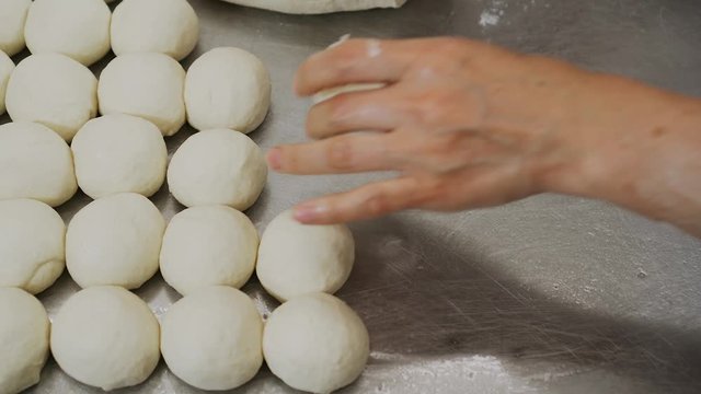 Process of making bread, bakery, pies. Dough balls on the table. Handmade process in bakery, kitchen, cafe, restaurant. Hands of chef working
