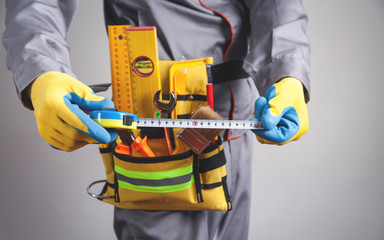 Caucasian worker holding a tape measure.