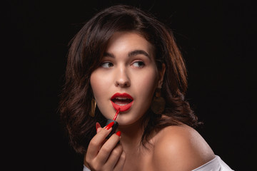 Beautiful woman with bright makeup posing isolated over black background.