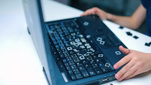 Closeup of a broken laptop in the hands of a child.
