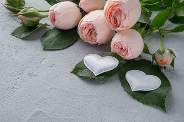 Beautiful peony bushy pink roses and two white hearts. Valentine's day, the concept of love and loyalty. Copy space.