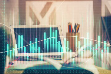 Financial chart drawing and table with computer on background. Double exposure. Concept of international markets.