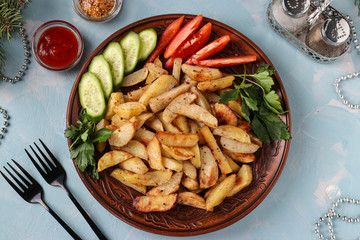 Baked potatoes served with tomatoes, cucumbers and parsley on a plate, Top view, Horizontal orientation