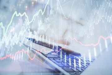 Forex graph hologram on table with computer background. Multi exposure. Concept of financial...