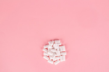 white bubble gum pills on pink background
