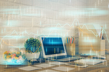 Double exposure of chart and financial info and work space with computer background. Concept of international online trading.