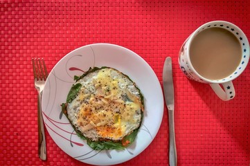 Mug of coffee and eggs on red table mat