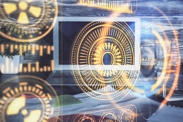 Computer on desktop in office with technology theme hologram. Multi exposure. Tech concept.