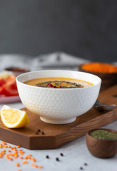 A bowl of thick red lentil soup served with lemon, dried mint and paprika. Turkish and Indian cuisine. Vertical orientation, copy space
