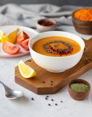 Thick red lentil soup served with lemon, dried mint and paprika. Turkish and Indian cuisine. Vertical orientation