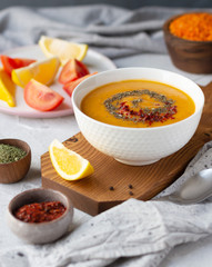 A bowl of thick red lentil soup served with lemon, dried mint and paprika. Turkish and Indian cuisine. Vertical orientation