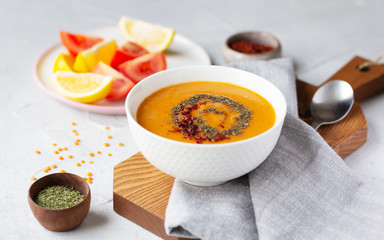 A bowl of thick red lentil soup served with lemon, dried mint and paprika. Turkish and Indian cuisine. Horizontal orientation