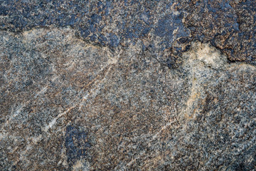 The texture of the stone overgrown with moss. Background image of a boulder