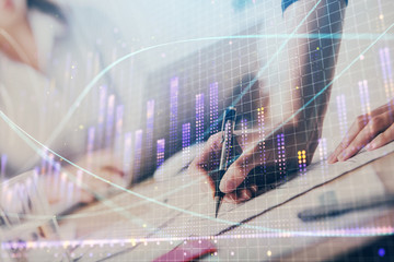 A woman hands writing information about stock market in notepad. Forex chart holograms in front. Concept of research. Double exposure