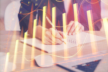 Forex graph on hand taking notes background. Concept of research. Multi exposure