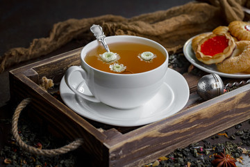 Obraz na płótnie Canvas Hot tea in a cup with kitchen accessories 
