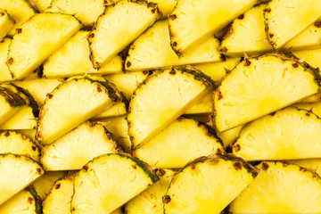 Pineapple juicy yellow slices background. Top view.
