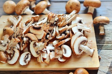 Royal fresh mushrooms on a wooden background. Sliced ​​champignons on a wooden board. Cooking process.