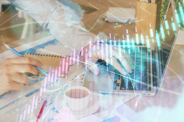 Forex graph with businessman working on computer in office on background. Concept of hardworking. Multi exposure.