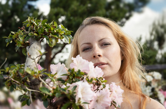 young woman among the flowers of azalea