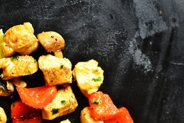 Traditional greek dish souvlaki. Kebabs on wooden skewers. Shish kebabs with tomatoes, mushrooms, pepper and lemon, top view, black concrete background. Place for text.