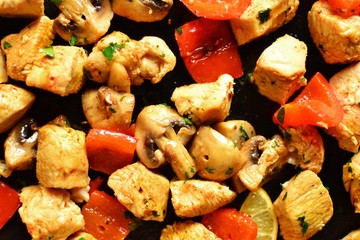 Traditional greek dish souvlaki. Kebabs on wooden skewers. Shish kebabs with tomatoes, mushrooms, pepper and lemon, top view, black concrete background. Place for text.