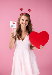 Happy young woman holding big heart