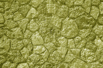 Wall made of old stones in yellow tone.