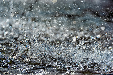 Fototapeta na wymiar Water splash with small drops in the fountain. Abstract natural, selective focus background
