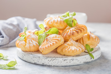 Profiteroles or gougeres  (choux à la crème) - French choux pastry balls filled with custard or cottage cheese sprinkled with powdered sugar